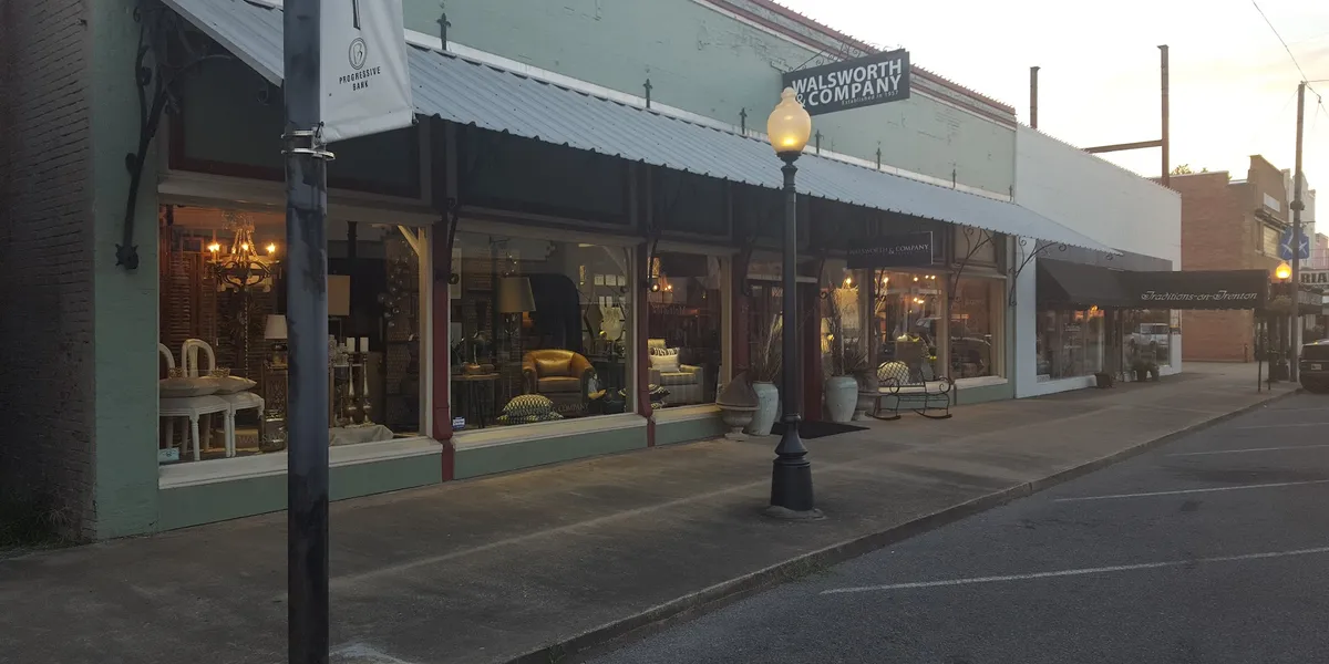 Newly remodeled showroom displaying high-end furniture pieces including solid burl wood dressers and genuine leather...