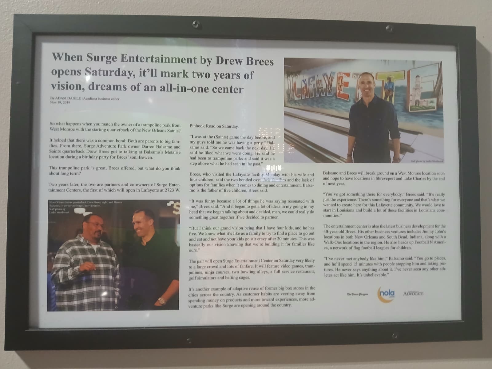 Framed newspaper article from The Advocate about Drew Brees and Surge Entertainment hanging on the wall inside Surge West Monroe