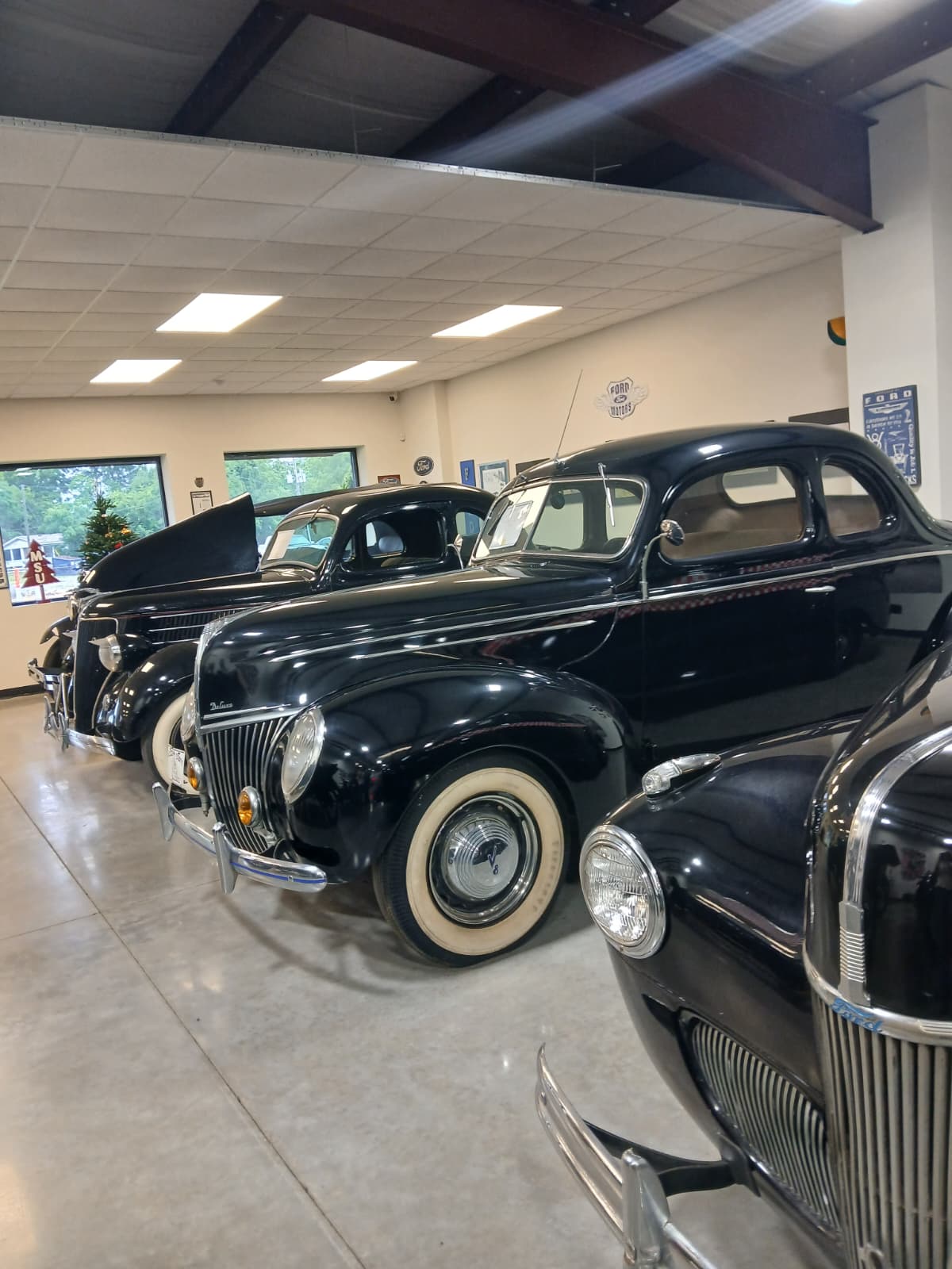 Row of vintage Ford V8 automobiles from the 1930s and 1940s inside Vintage Vehicles showroom West Monroe Louisiana